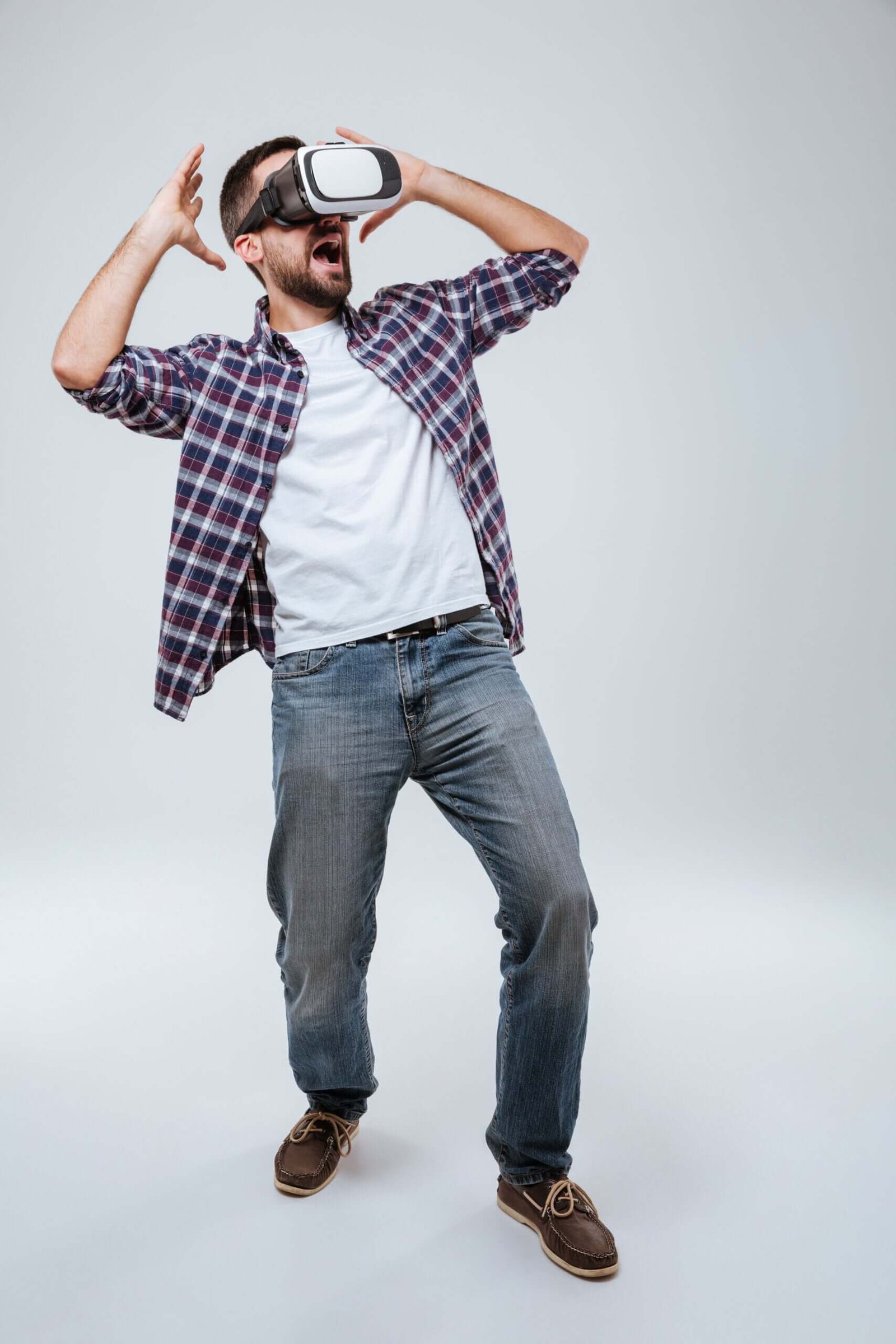 Vertical image Bearded man in shirt using virtual reality device